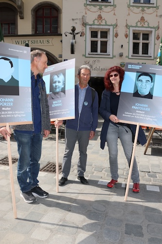 Drei Personen mit Tafeln des Opfers sind zu sehen. Links ist Gabriel Laszlo, und rechts ist Nadja Rackwitz-Ziegler zu sehen