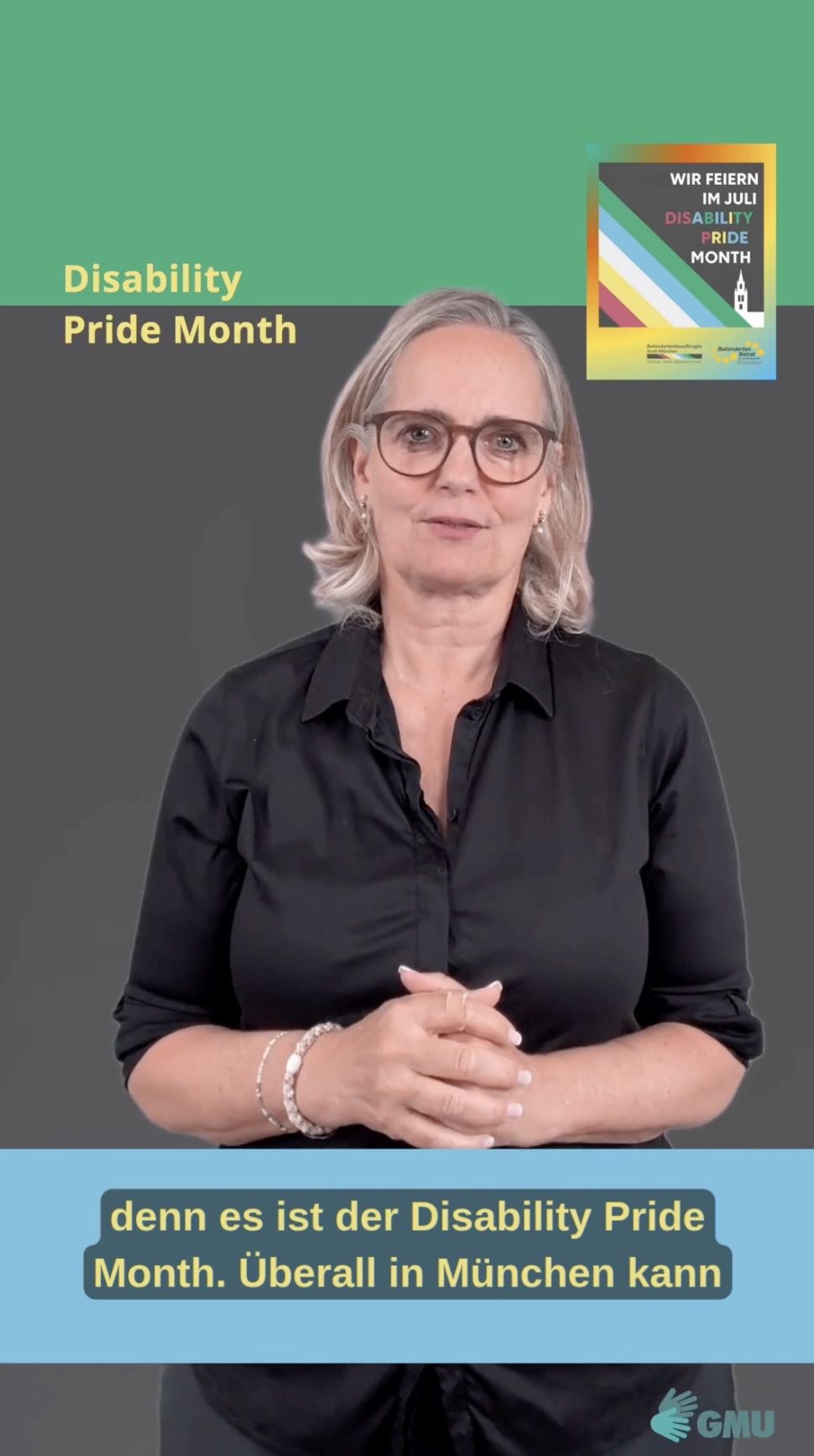 Eine Frau mit schulterlangem blonden Haar und Brille steht vor einem zweigeteilten Hintergrund in Grün und Dunkelgrau, Sie trägt eine schwarze Bluse. Links oben steht der Schriftzug „Disability Pride Month“. Rechts oben ist ein Plakat mit der Aufschrift „Wir feiern im Juli Disability Pride Month“ und einem diagonalen Streifenmuster in verschiedenen Farben. Am unteren Bildrand sind gelbe deutsche Untertitel auf einem hellblauen Balken eingeblendet. Rechts unten befindet sich das Logo „GMU“.
