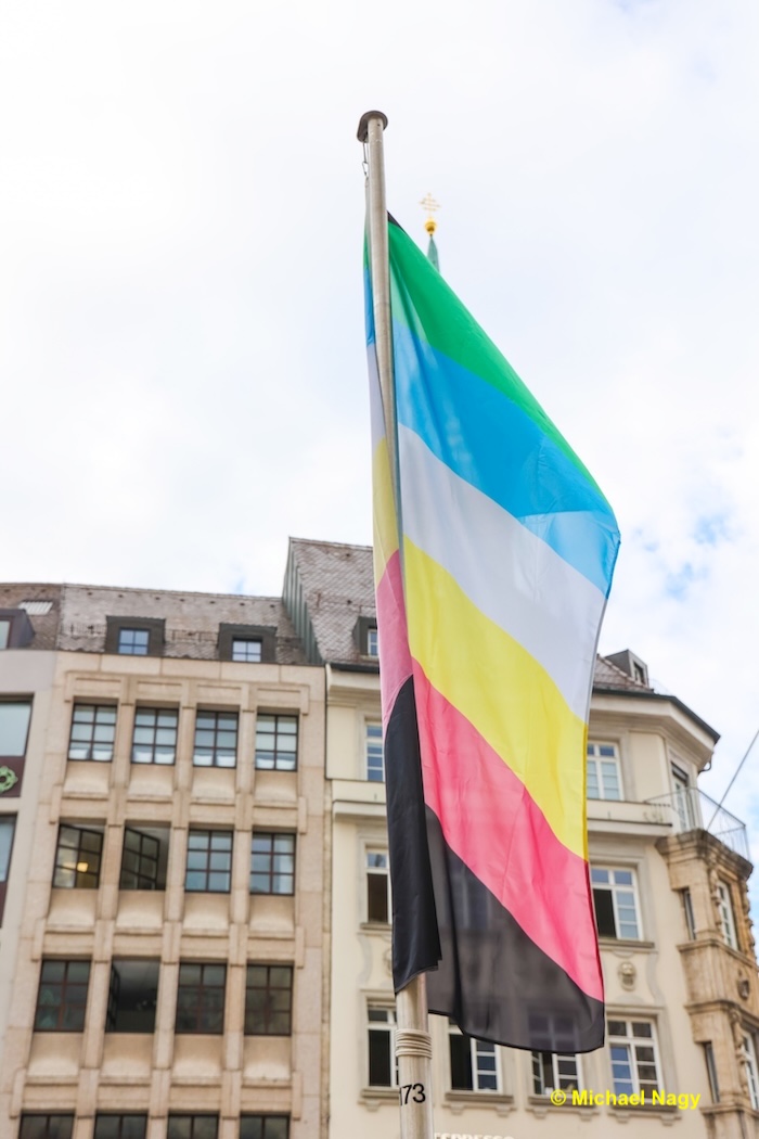 Wehende Fahne mit den Farben des Disability Pride Month