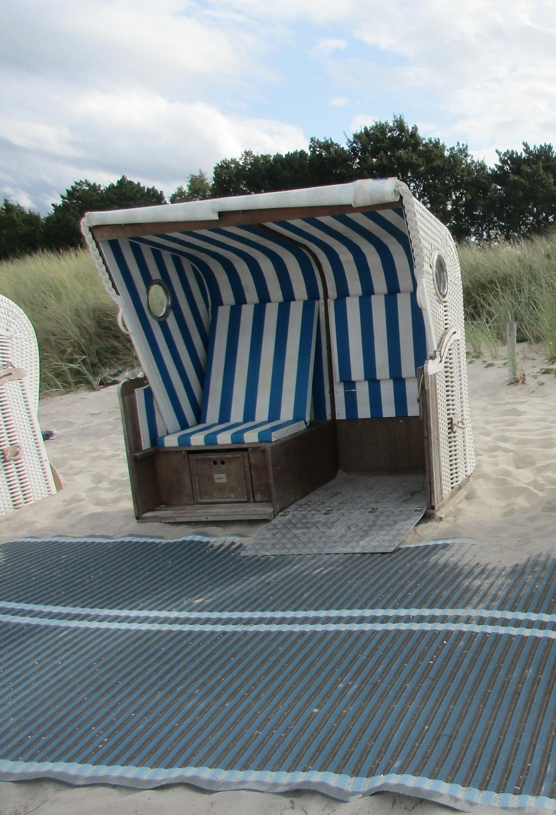 Zu sehen ist ein Strandkorb, der für eine Person im Rollstuhl und eine Person ohne Rollstuhl geeignet ist.